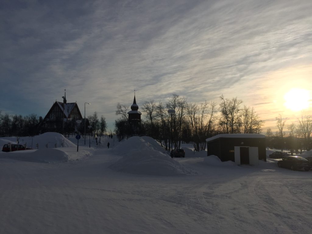 Kiruna around 2 PM in the winter with sun dipping below the horizon on a wintry oasis