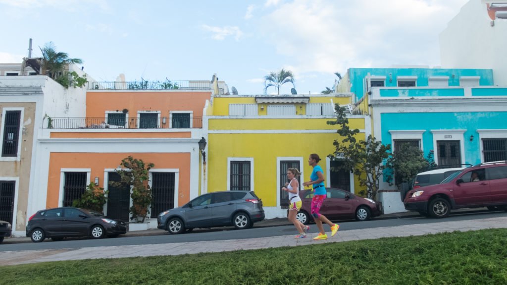 runners in Old San Juan against three colorful houses