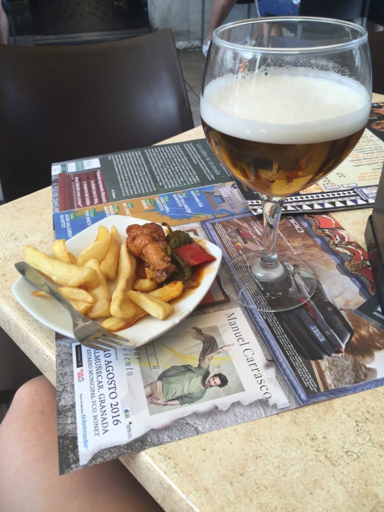 A large beer and a portion of french fries with chicken stew at a tapas bar in Granada