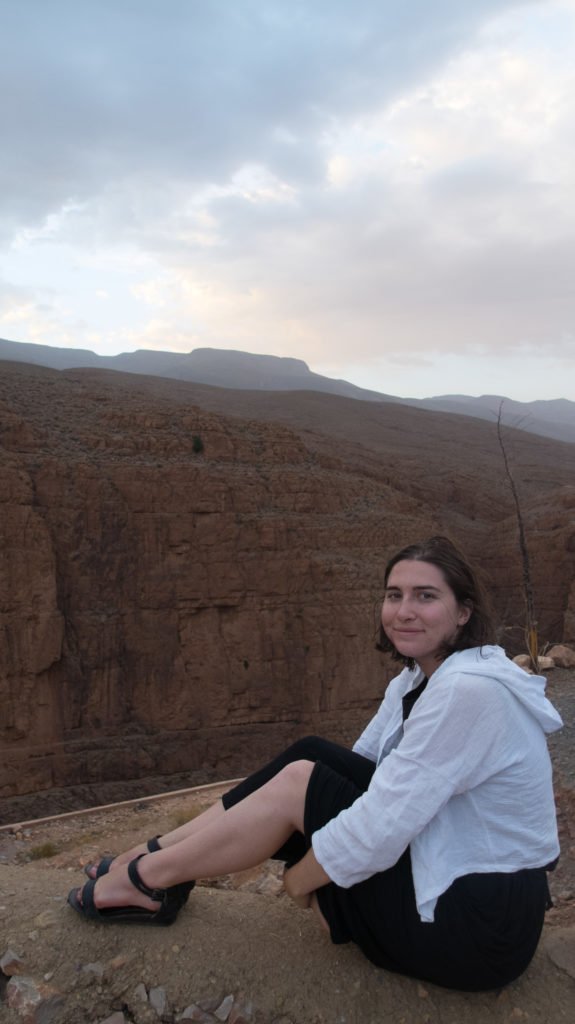 Allison wearing a dress that comes down to her knees and a white light linen jacket