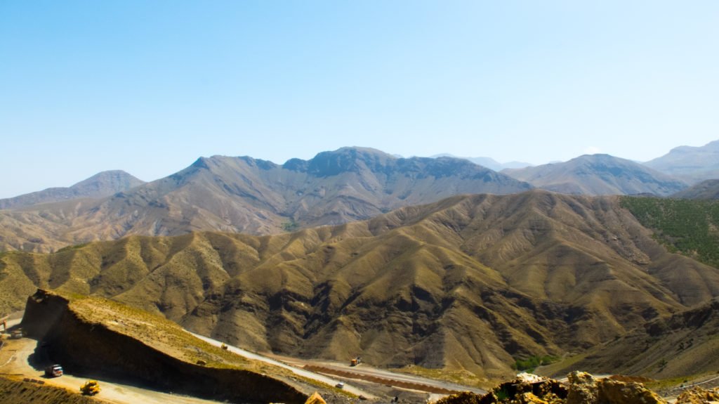 Atlas mountains in Morocco with a road below it at a mountain pass on a sunny day