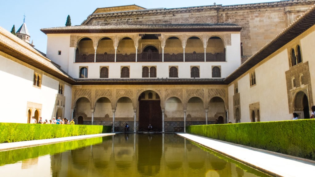 The courtyard in the Alhambra with archways, detailing and shallow pool