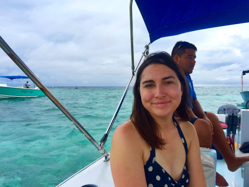 Allison Green in a polka dot bathing suit while visiting Belize, sitting a boat.