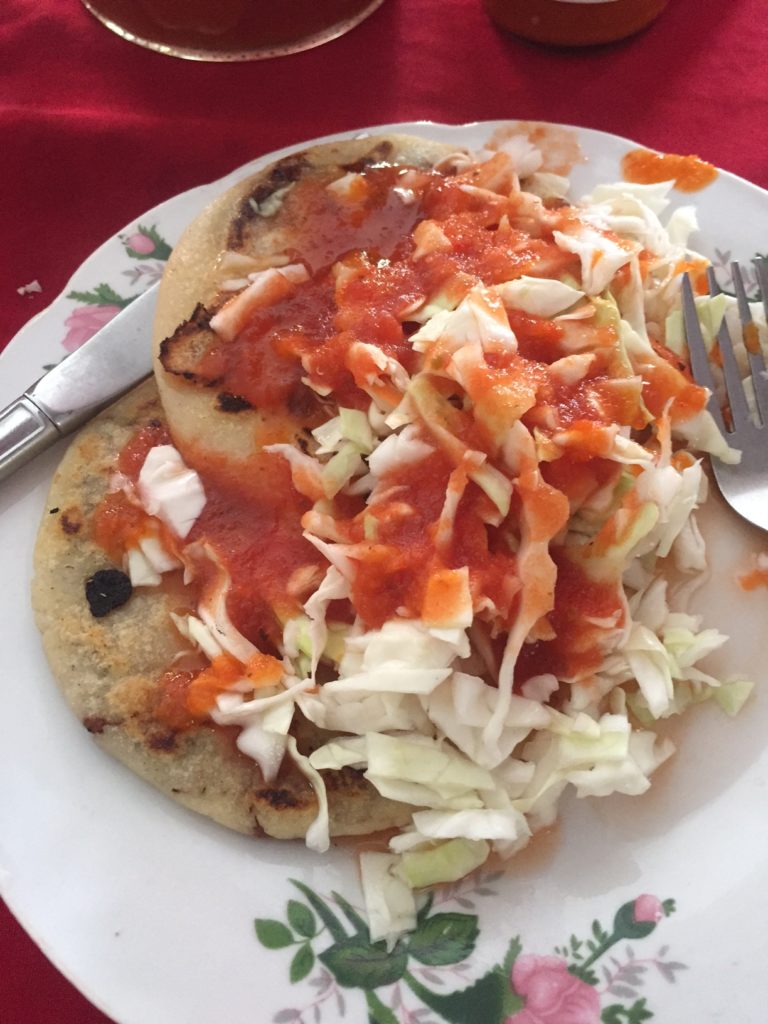 pupusas covered in cabbage and a mild tomato sauce eaten in san pedro belize