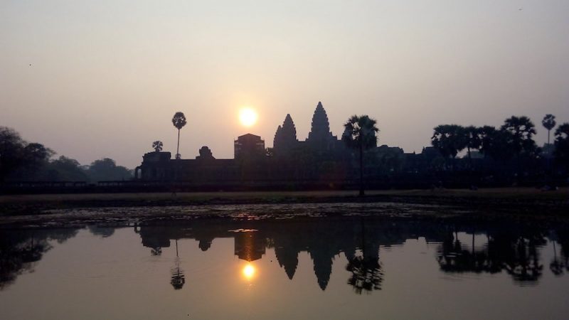 View of Angkor Wat at sunrise with the temple skyline reflected in the pond