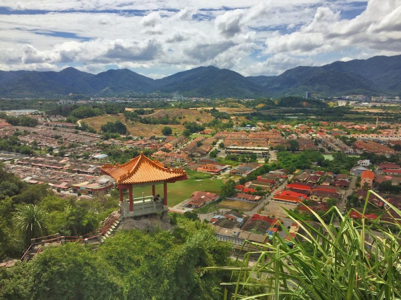 View over the landscape in Malayisa with a lookout tower and mountains in the distance