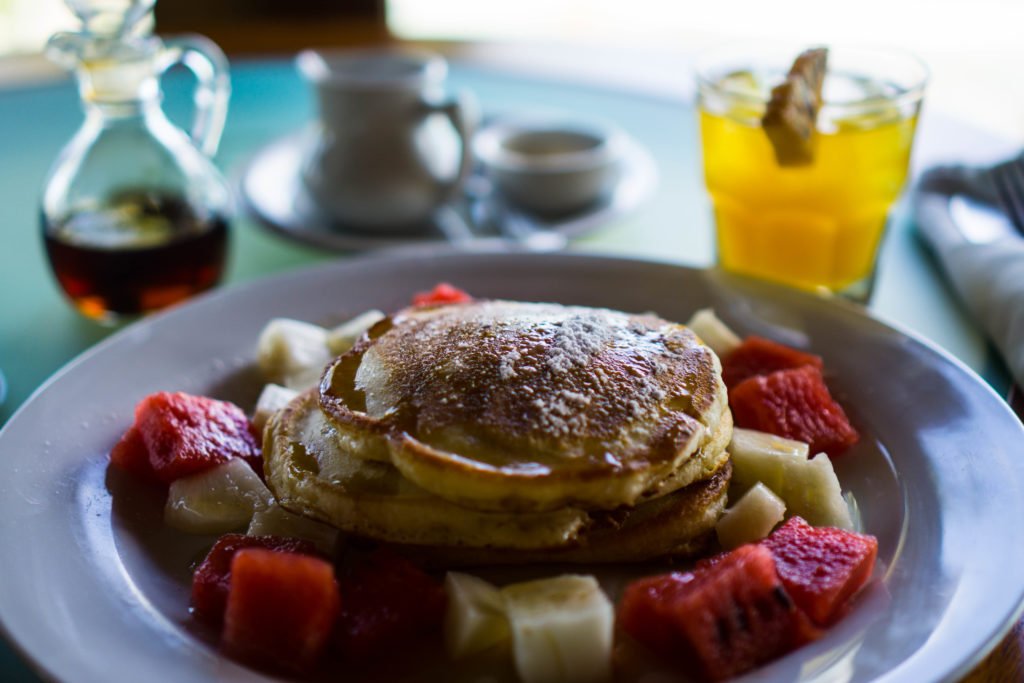 fancy breakfast in little corn with juice, pancakes, and fruit