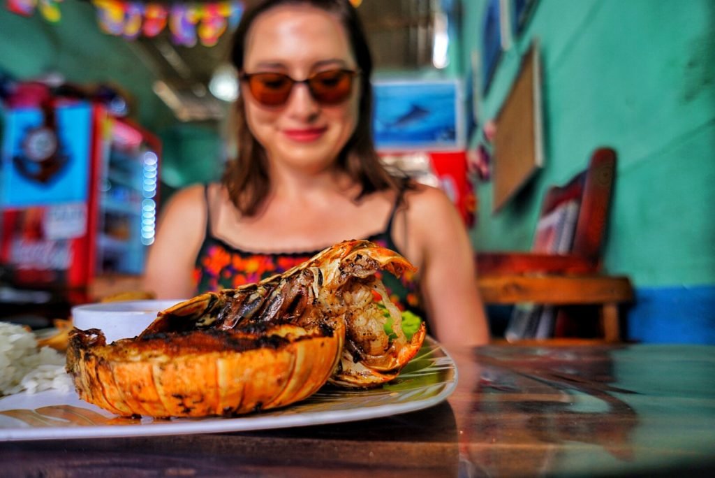 Allison Green eating a lobster tail while at a restaurant in Nicaragua