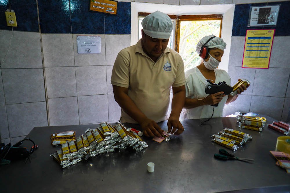 a man and a woman in matagalpa making and packaging chocolates