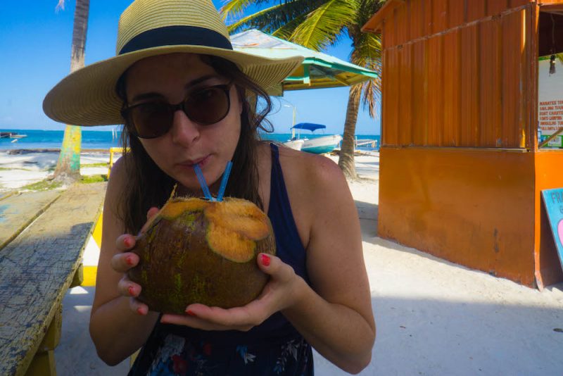 Allison Green sipping a coconut out of a straw in Caye Caulker