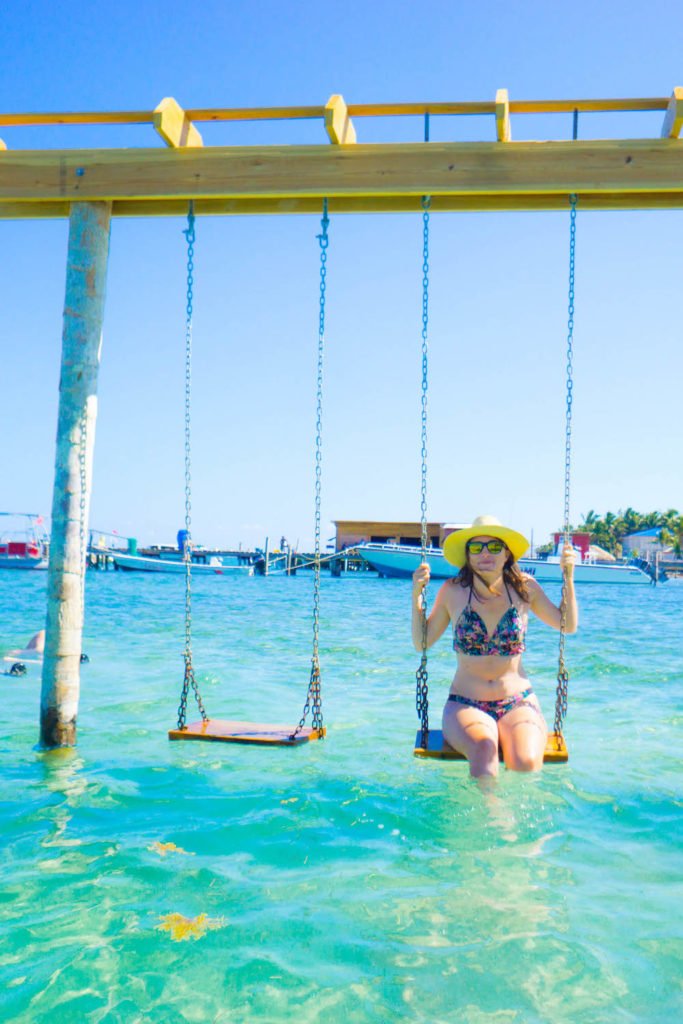 Allison Green sitting on a swing in the waters in Caye Caulker