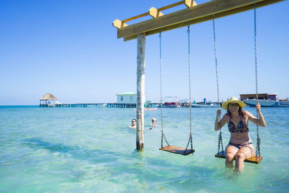 Allison sitting on a swing in Caye Caulker enjoying the sunny weather in the dry season