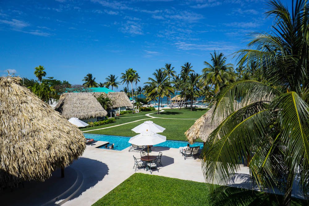 a bright sunny day at victoria house looking over the palm trees, grass, and pols