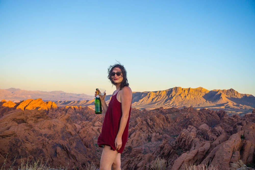 Allison with a bottle of champagne at the Valley of Fire at sunset