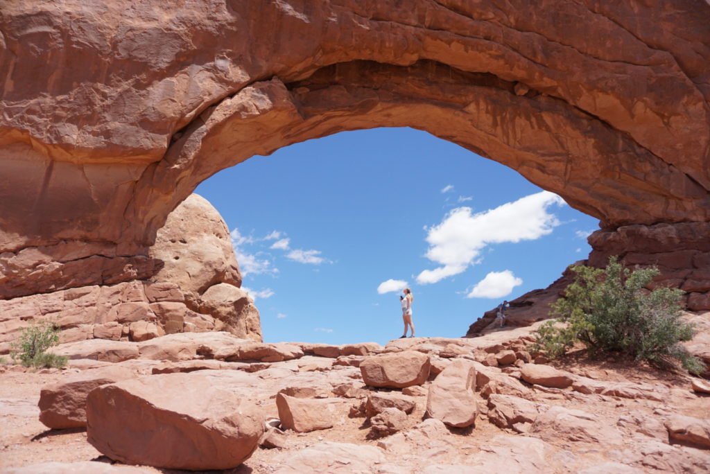 standing in the middle of an arch in utah