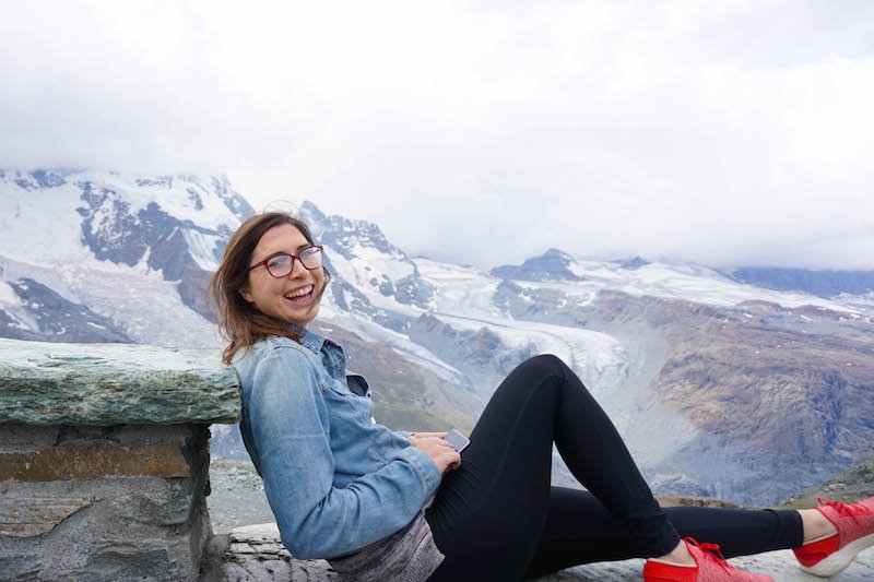 allison smiling atop a mountain