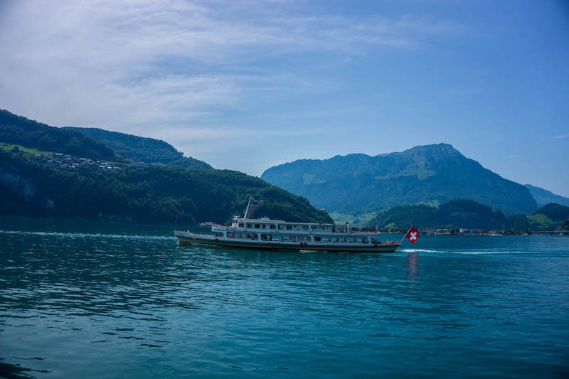 boat on lake lucerne with red flag with plus sign on in (swiss flag)
