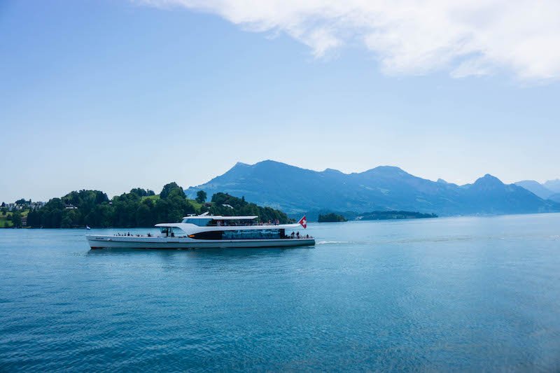 A boat on Lake Lucerne with beautiful clear skies and tranquil waters