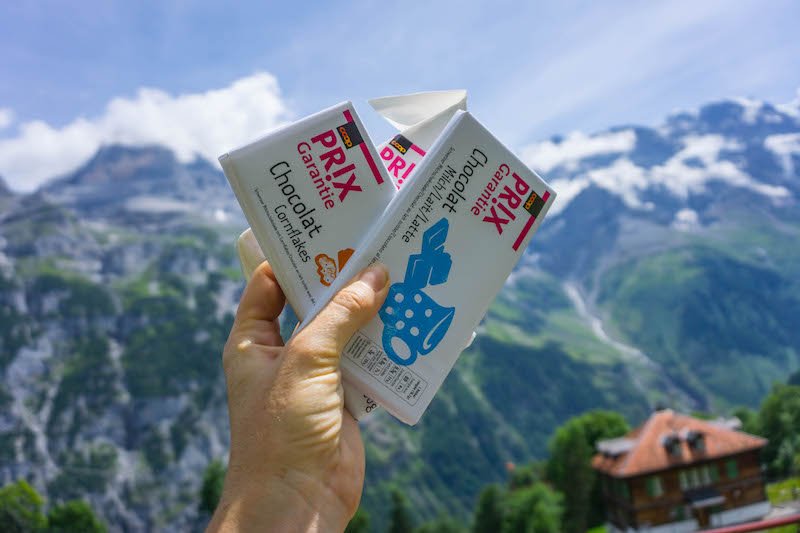 Swiss chocolates being held up in the air with mountain background