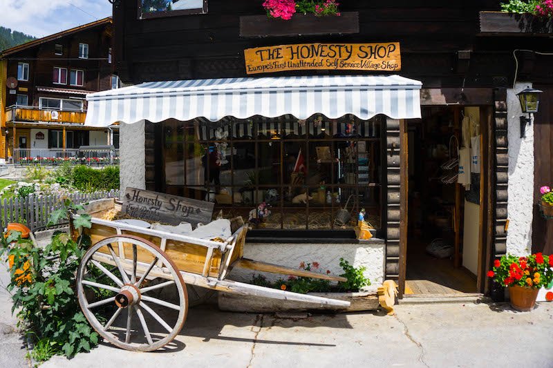 [storefront with wheelbarrow reading 'the honesty shop'] in Gimmelwald, one of the best places to visit in Switerland