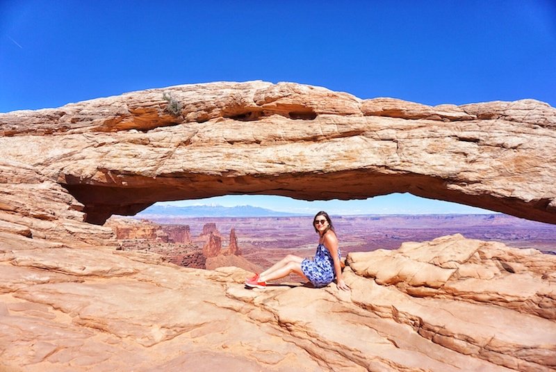 Allison visiting Mesa Arch in Canyonlands national park sitting in the middle of Mesa Arch