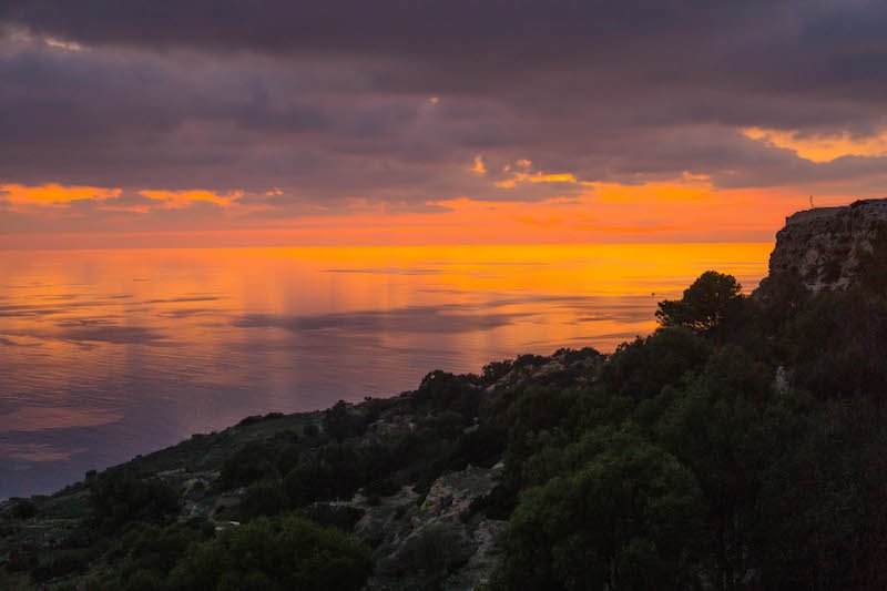 Photo of a sunset in Malta at Dingli cliffs with orange and purple tones