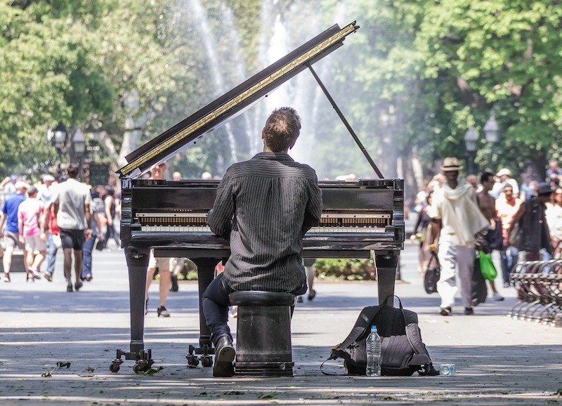 street performer playing a piano in washington square park.