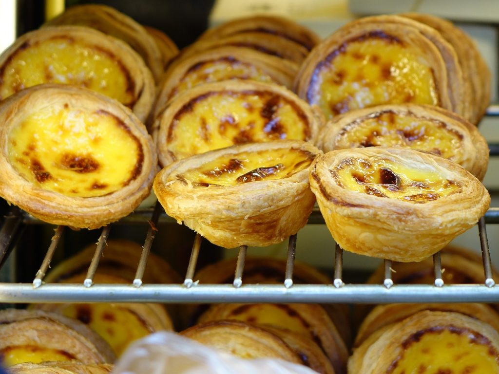 flaky golden egg custard pastries in a bakery window