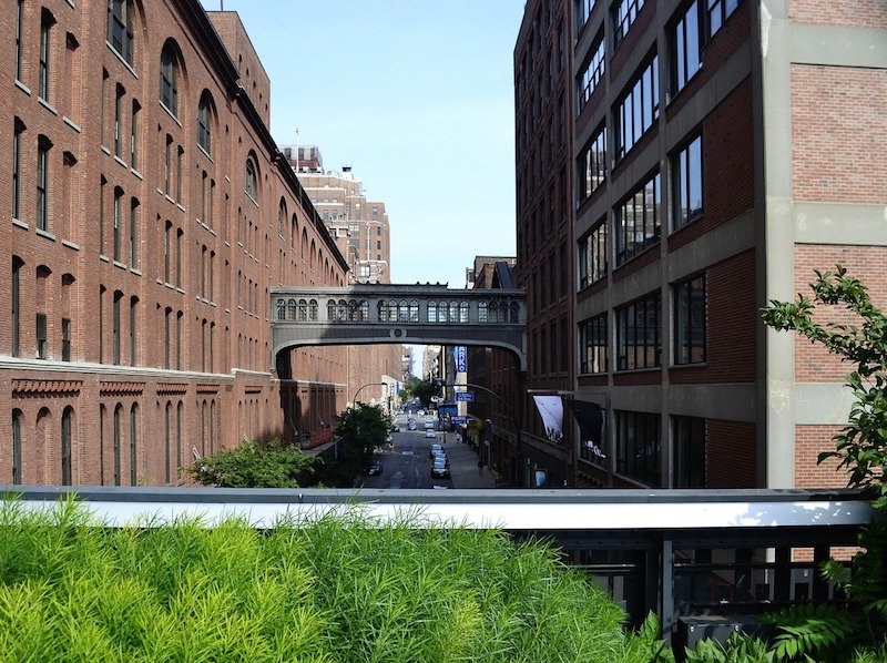 view from walking the highline on a new york city itinerary, of a bridge over the walkway