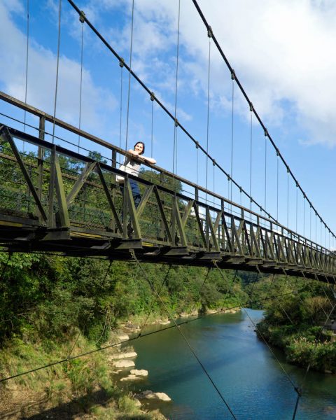 Allison Green standing at the Shifen old town waterfall bridge