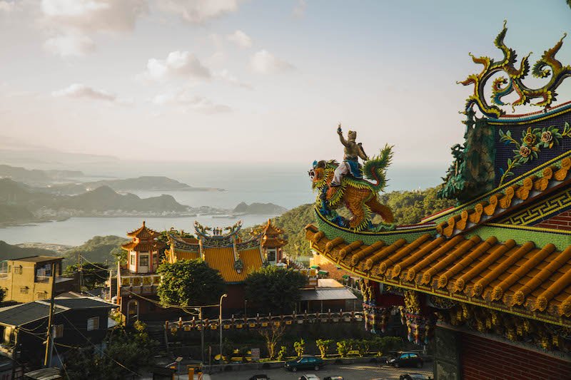 interesting detail of a temple with a view of the coastline of jiufen area below it