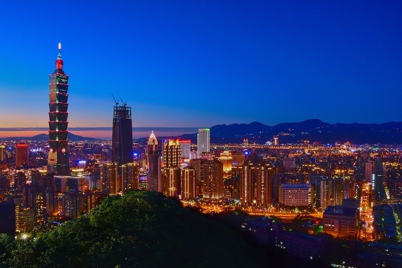 the skyline of taipei seen at night with beautiful colors lighting up, taipei 101 seen from elephant mountain in the city outskirts