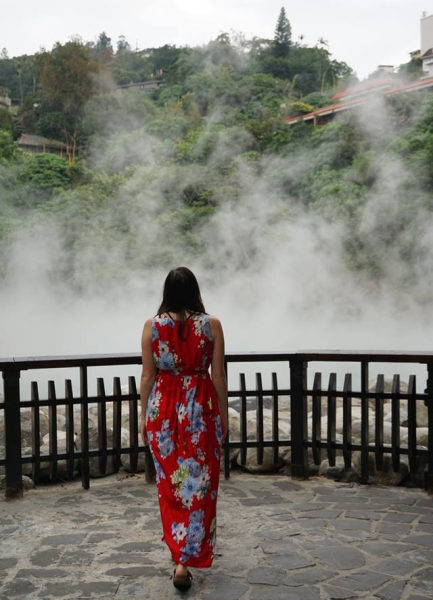 Allison Green in Taipei at the Beitou hot springs in a red maxi dress walking towards the spring