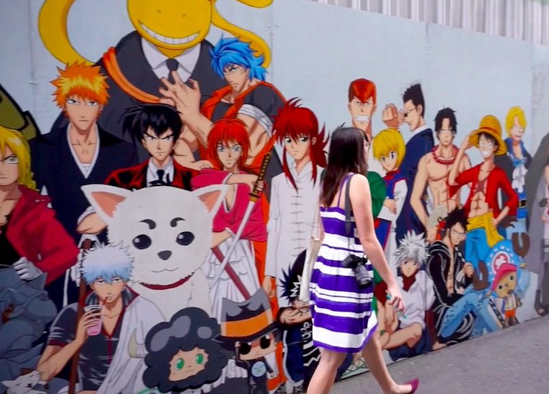 Allison Green walking past a wall of anime painted murals