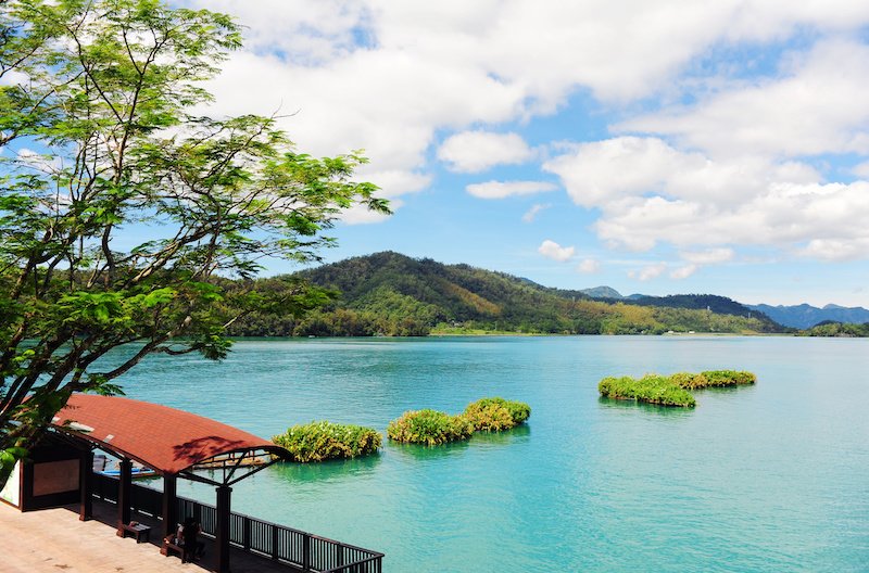 Sun moon lake scenery in Taiwan with blue lake, cloudy sky, and little islets in the water