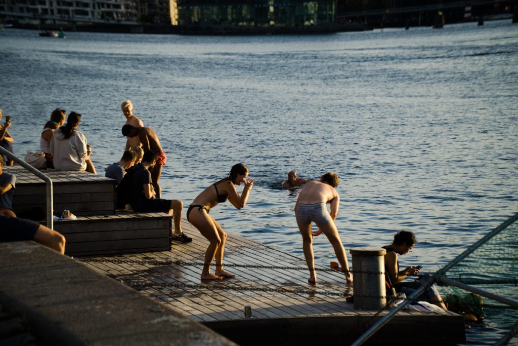 people in their swimsuits jumping in the canals of copenhagen