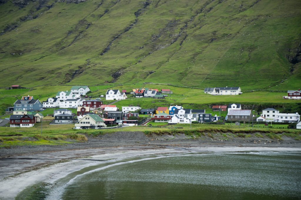 colorful houses on the grassy areas around the beach of hvalba