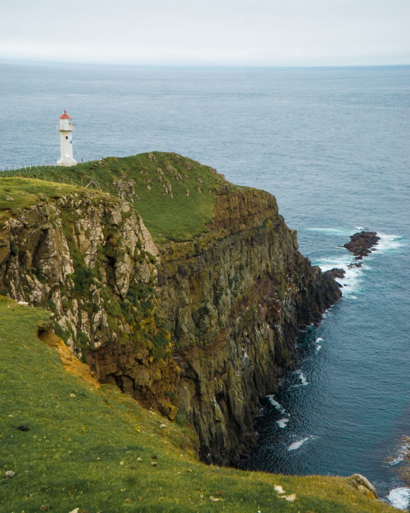 lighthouse seen on the edge of the islands of the faroe islands at the southernmost point of the island