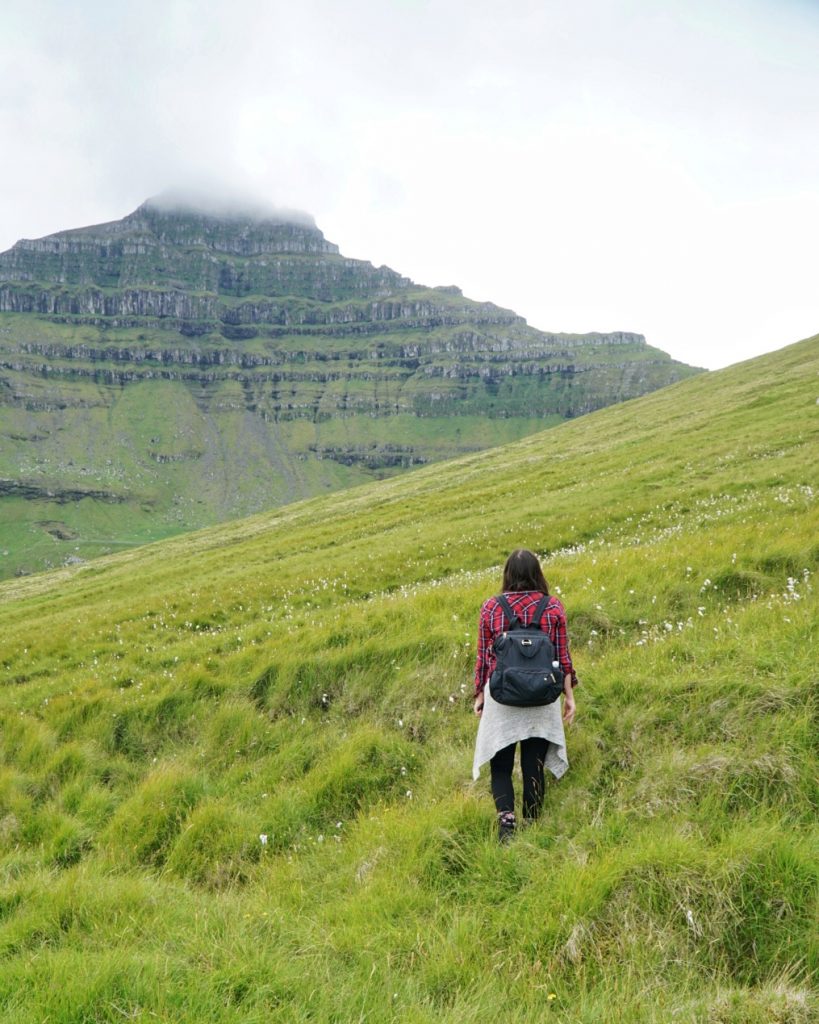 allison enjoying the faroe islands in the scenery filled with green grass