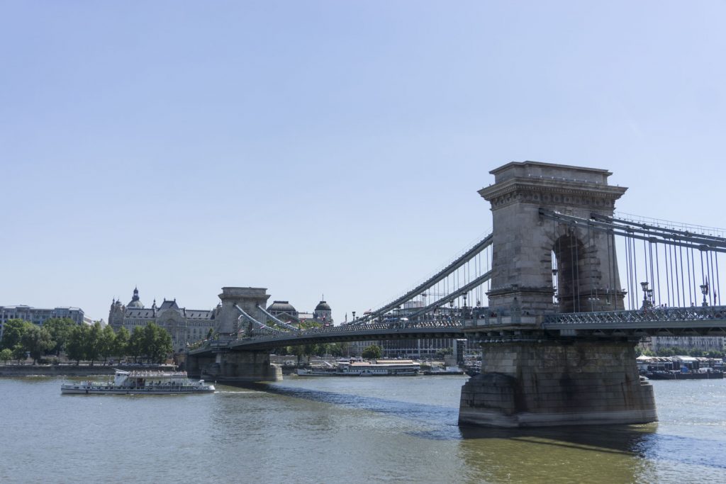 a view of one of the bridges in budapest, the famous chain bridge which part of a unesco site, spanning the danube river to connect both buda and pest, two sides of one city