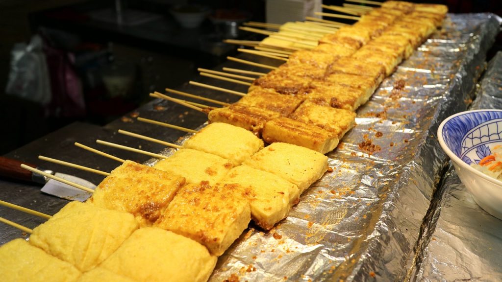 skewers of tofu slathered in a sauce in taipei night market