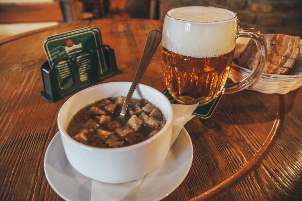 A giant mug of Pilsner with a lot of foam (the way it is supposed to be served) and a bowl of garlic soup.