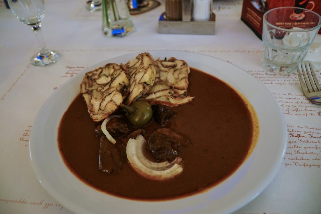 A traditional plate of Czech goulash with bread dumplings at a popular cafe on a food tour of Prague 