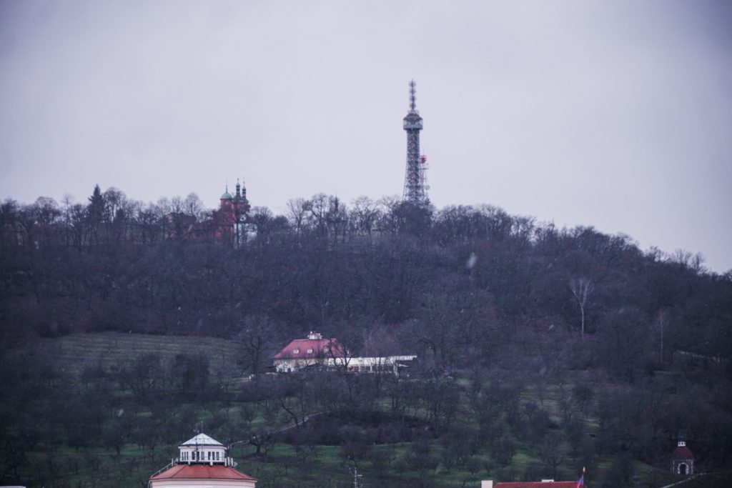 Desolate winter landscape of the large Petrin Park in Prague on the Castle District side of the Vltava River, with a view of the Petrin Tower (which looks like a small version of the Eiffel Tower)