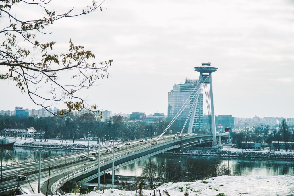 View of Bratislava's UFO Bridge as seen in the winter time, with a road leading to it, crossing the great Danube River.