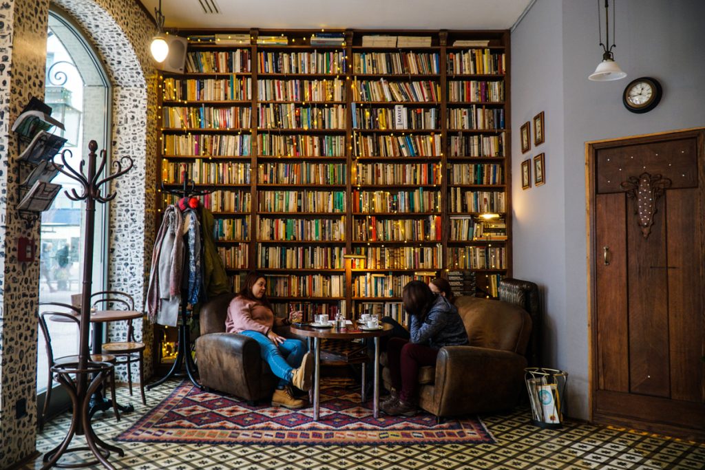 A bookshelf covered in fairy lights in a cute cafe in Bratislava Slovakia