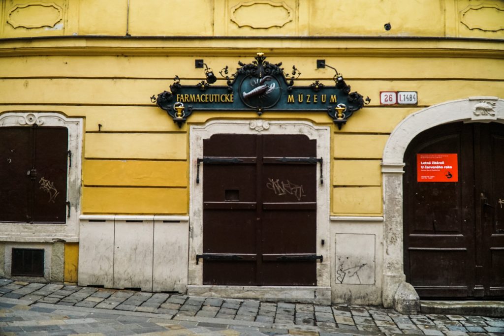 yellow building with a sign that reads "pharmacy museum" in Slovakian language