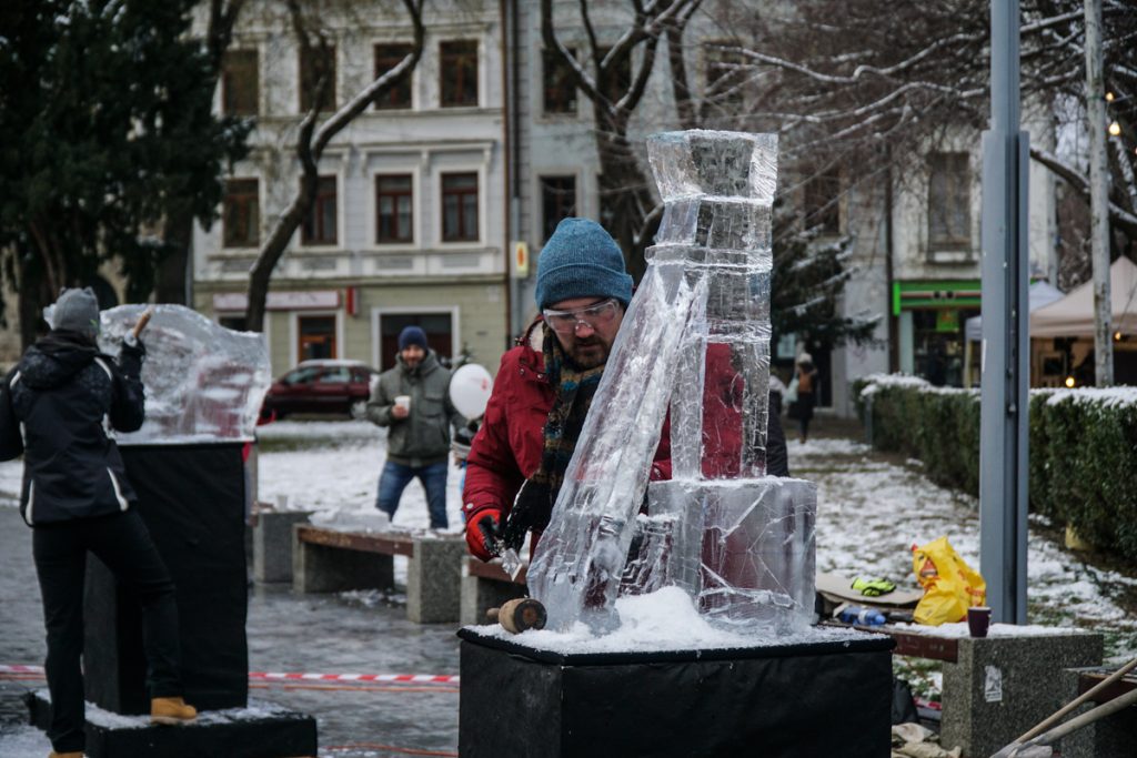 A man carving a unique ice sculpture in BRatislava in public on one of the city squares