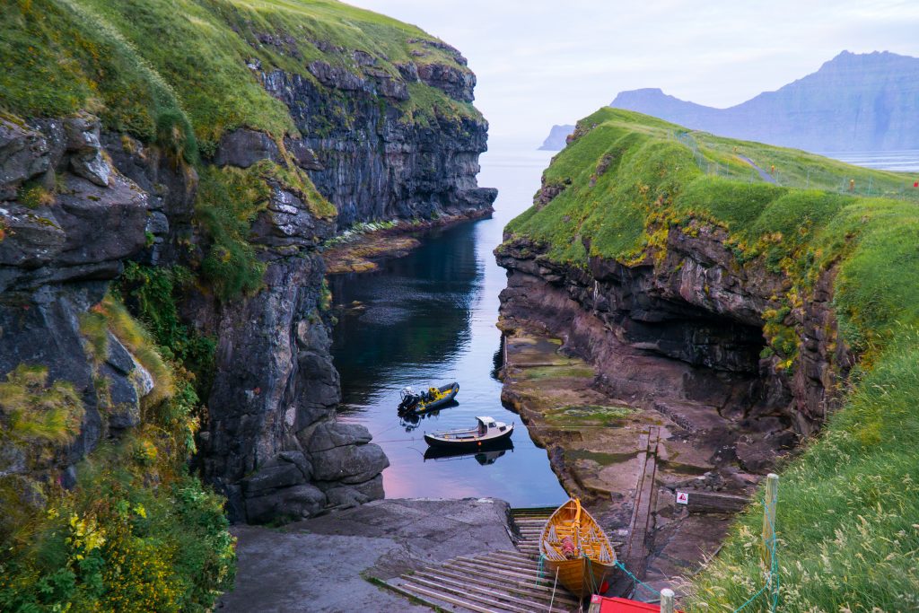 two small little boats at sunset in gjogv harbor in the faroe islands