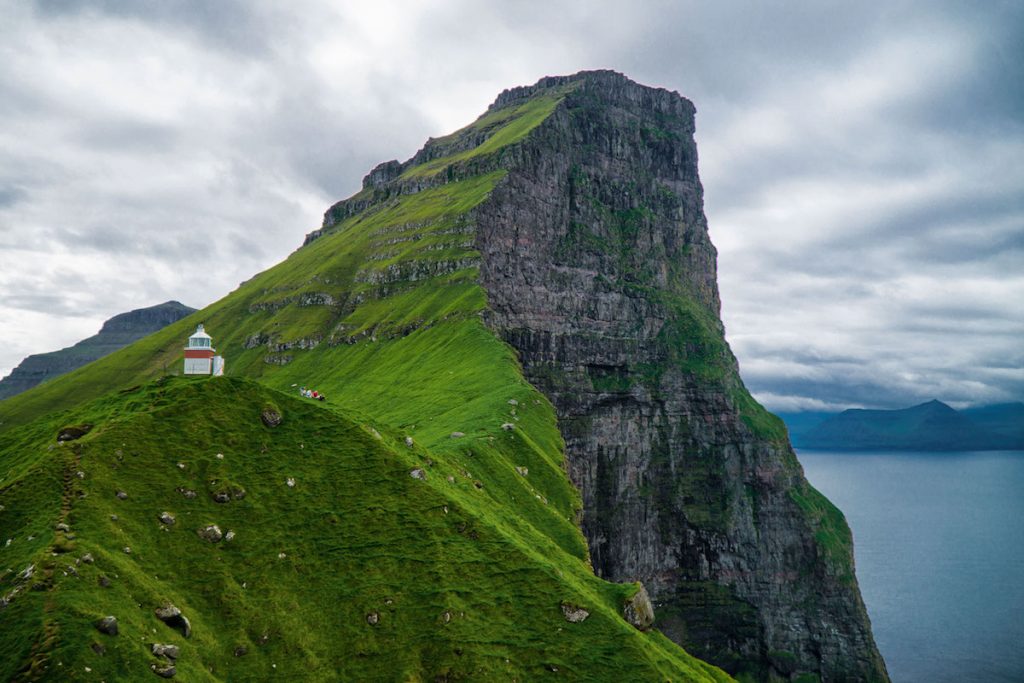 small lighthouse and epic scenery behind it